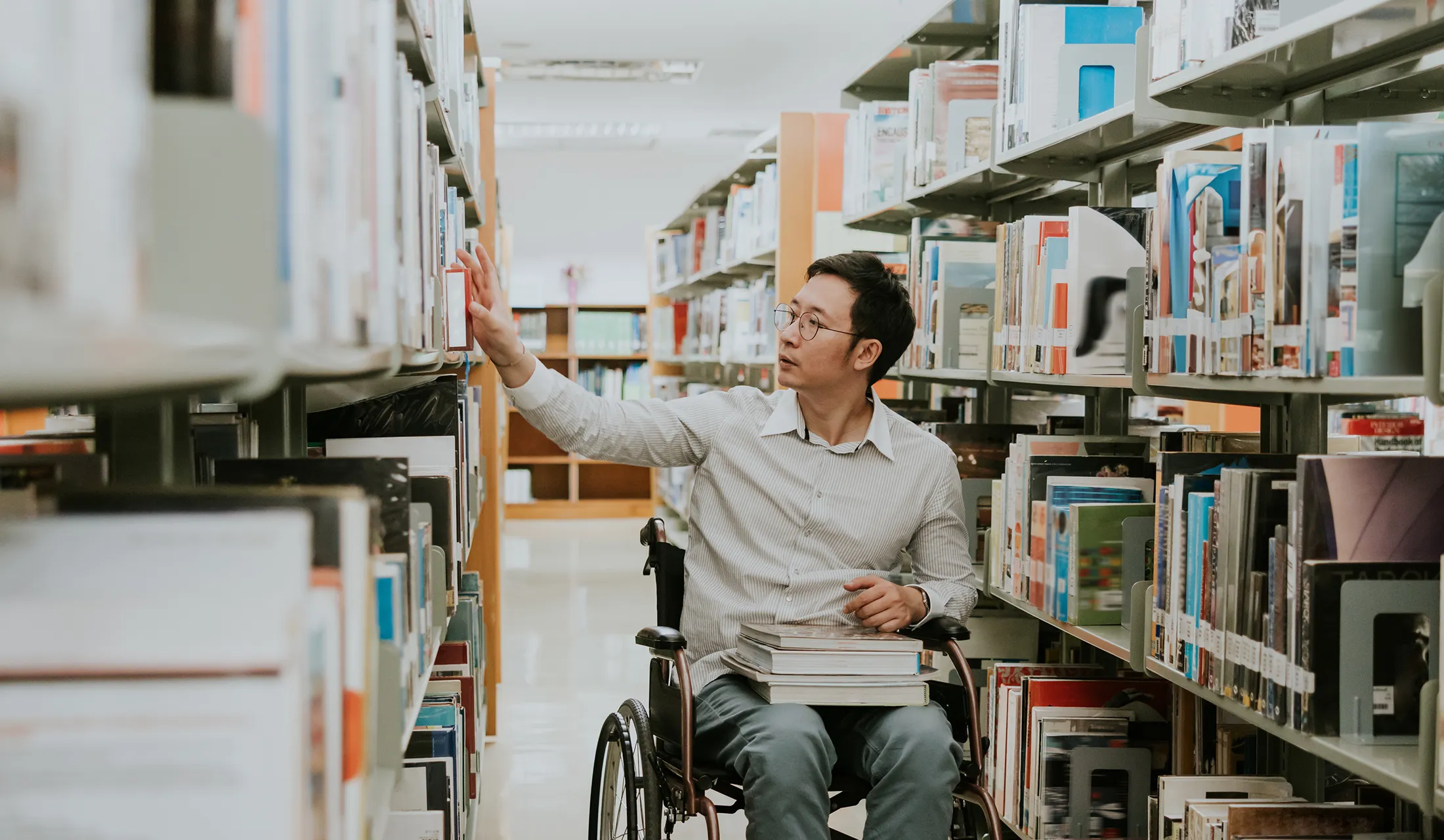iStock-1470256564 student in a wheelchair in a library
